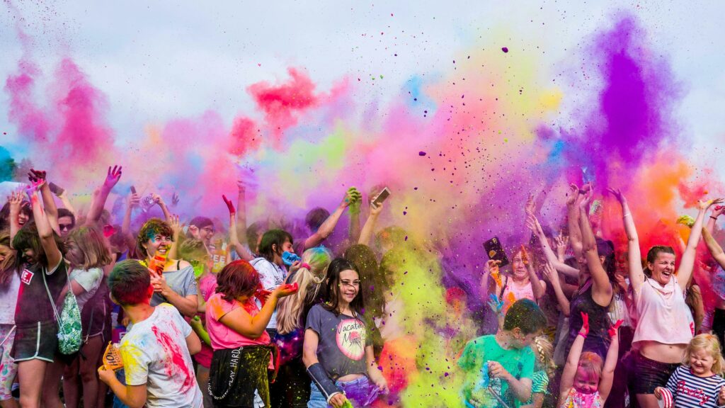 pexels photo 1684187 1684187 A joyful crowd covered in vivid colors celebrates a festival outdoors with flying powder.